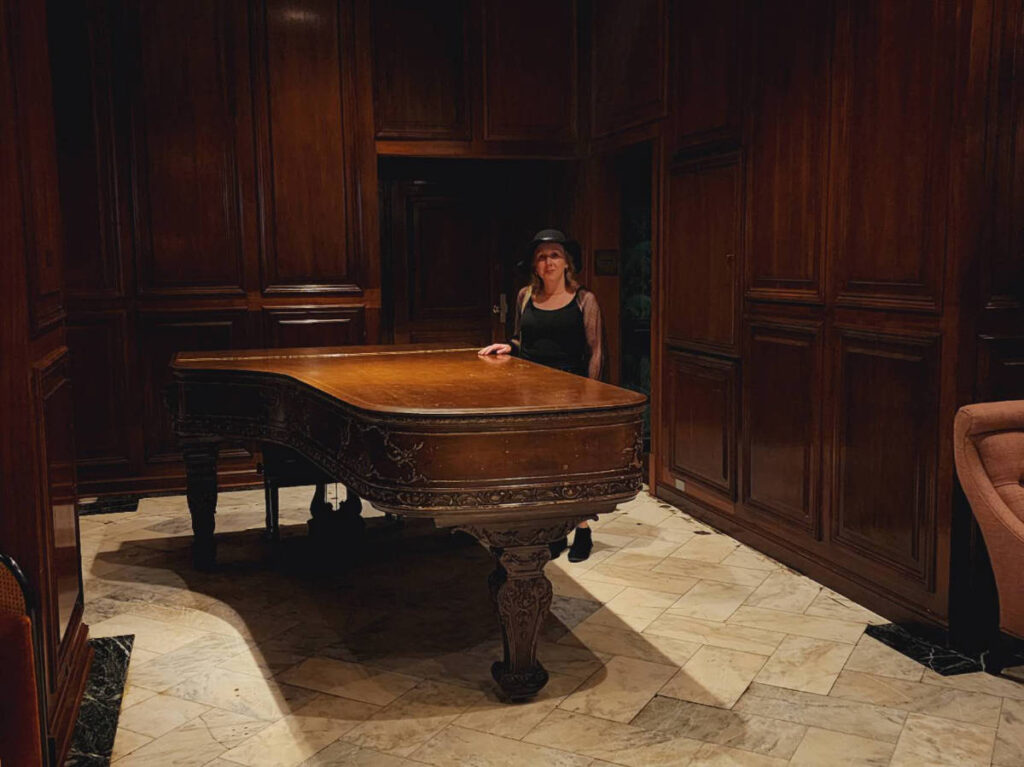 The author Sarah Heath and a piano at The Adolphus Hotel