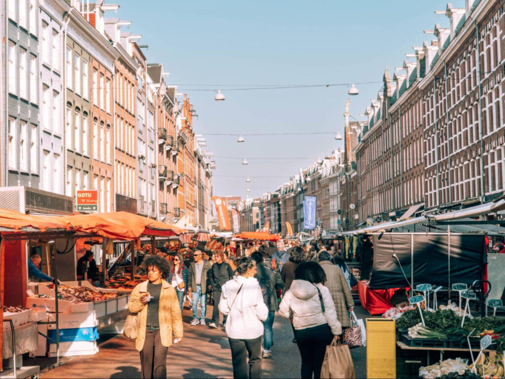 View of the busy Albert Cuyp Market with the stalls and tall buildings around