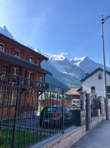 A house nestled against a majestic mountain backdrop