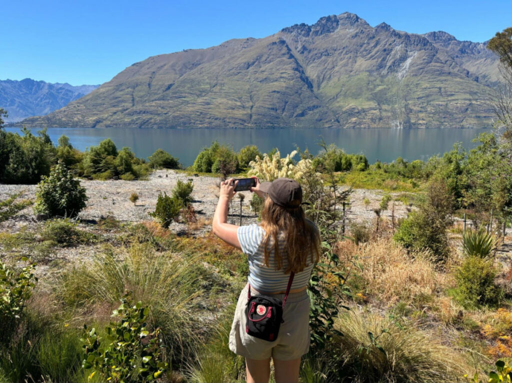 A woman taking a photo of the views at The Amon Hen lookout
