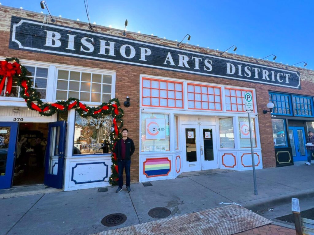 A man standing in front of the The Bishop Arts District
