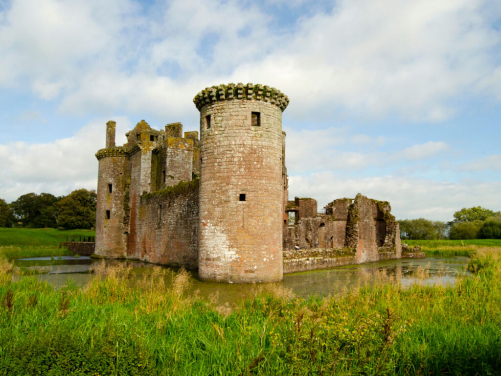 View of the Caerlaverock Castle ruins surrounded by waters