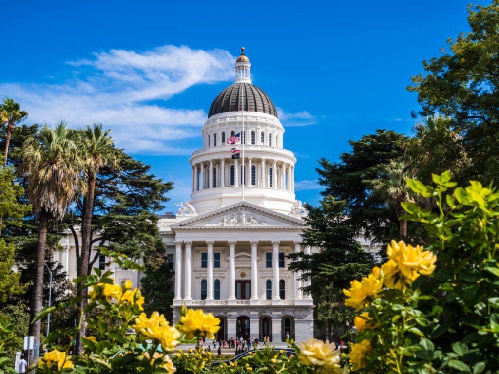 Outside view of the The California State Capitol building with beautiful yellow flowers in the foreground