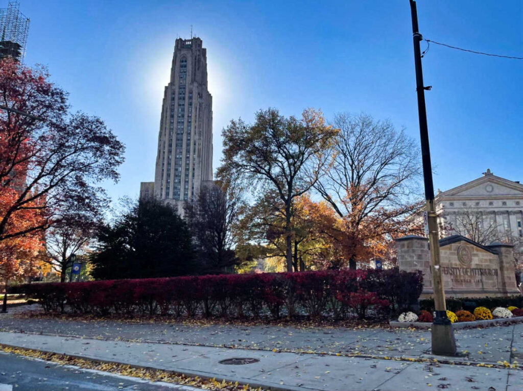 Perspective view of the Cathedral of Learning surrounded by fall foliage