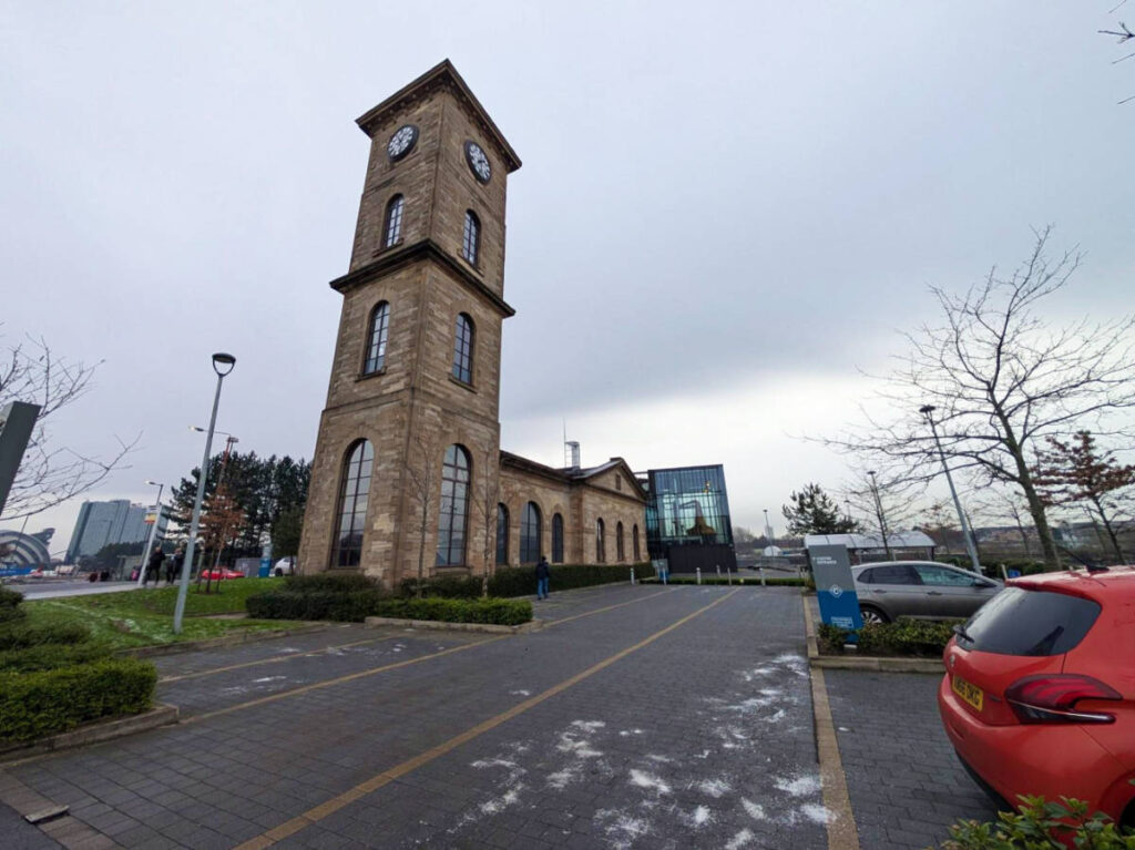 View of the glass walled Clydeside Distillery near the clock tower seen from a distance