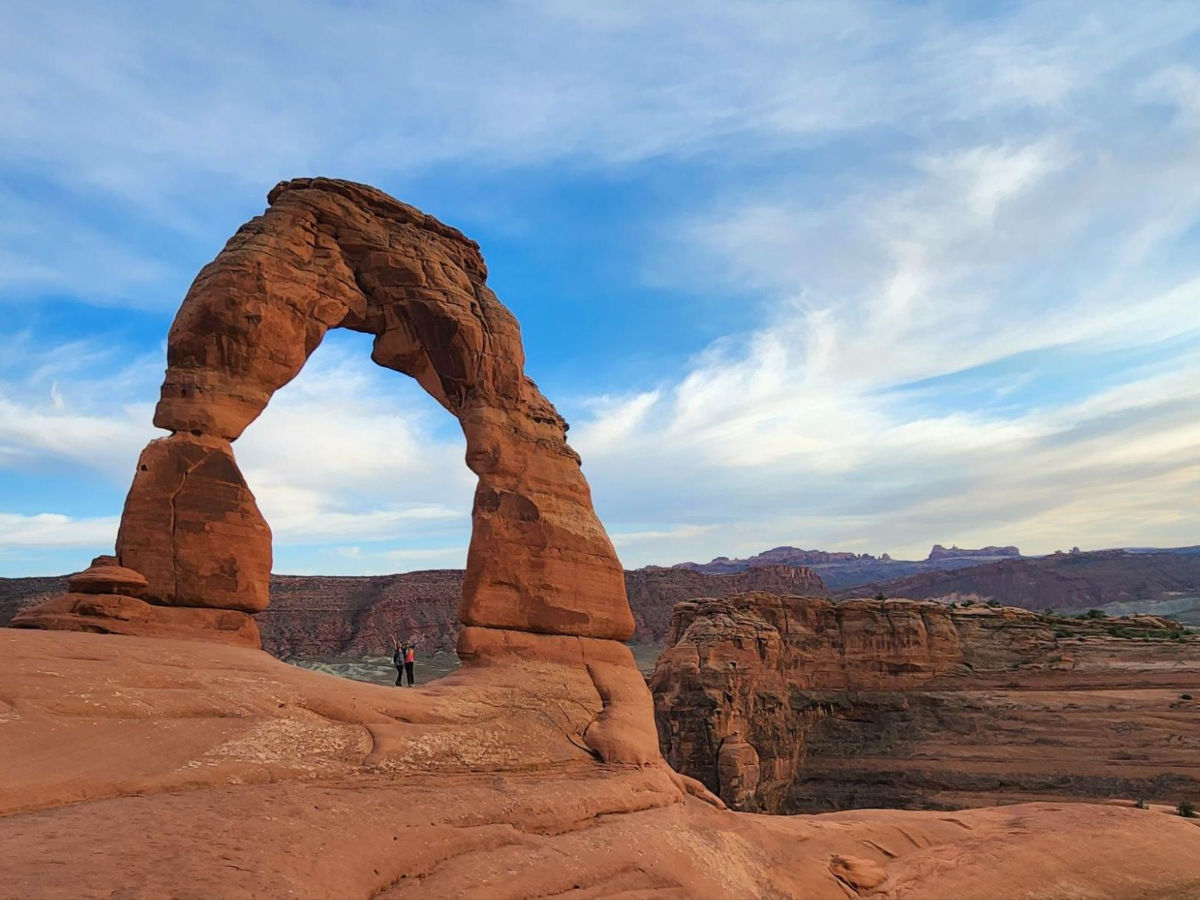 Travel Lemming editor Abigail and her friend standing beneath Delicate Arch
