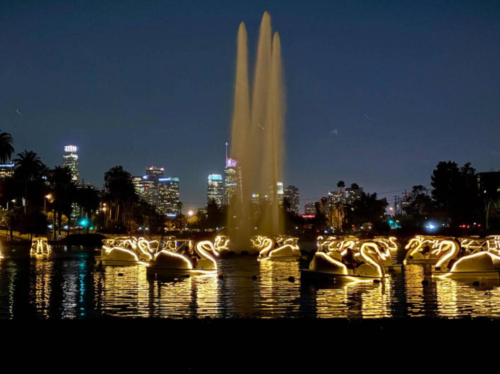View of the fountain lake with swan boats illuminated at night