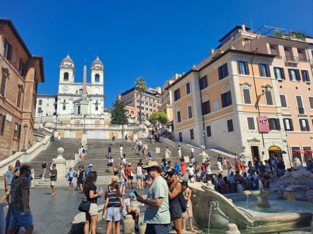Tourists at the Fontana della Barcaccia backdropped by the Spanish Steps