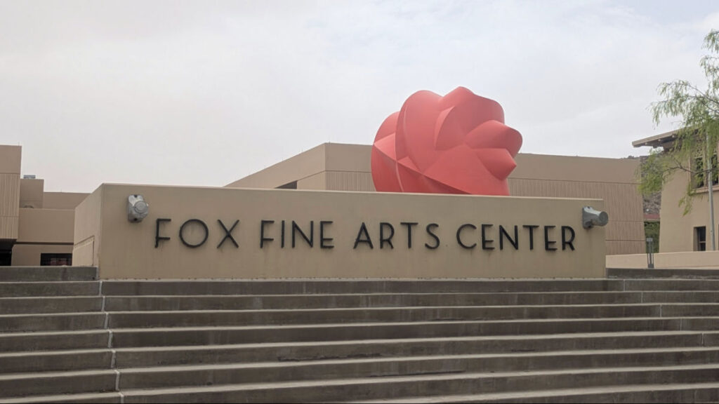 A large red sculpture  behind the Fox Fine Arts Center sign at the University of Texas at El Paso