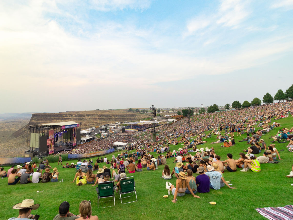 Large crowd of music fans sit on the lawn at The Gorge Ampitheater