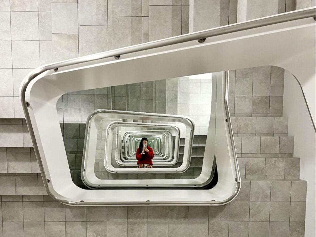 Author Lia taking a photo of the Infinite Staircase by Leandro Erlich at Kamu Museum