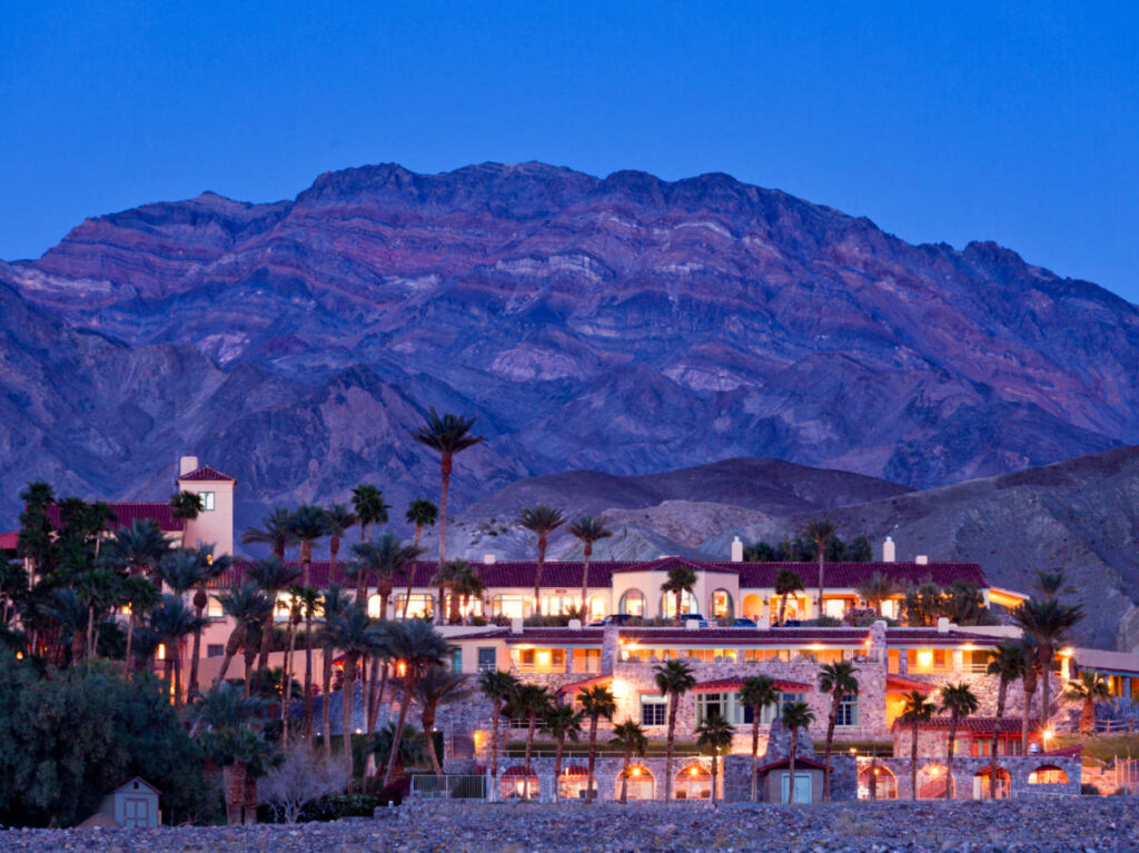 Night view of the facade of the The Inn with mountain views in the background at Death Valley