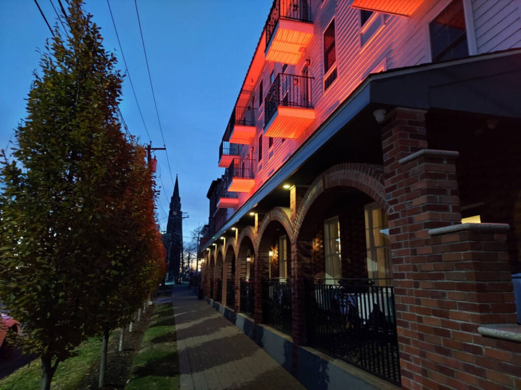 View of the illunating colorful lights on the exterior of The Orange Inn Boutique Hotel at night