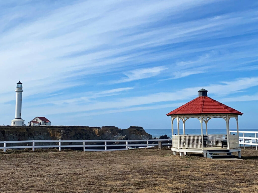 View of the Point Arena lighthouse on the rocky cliffs and the gazebo in Point Arena