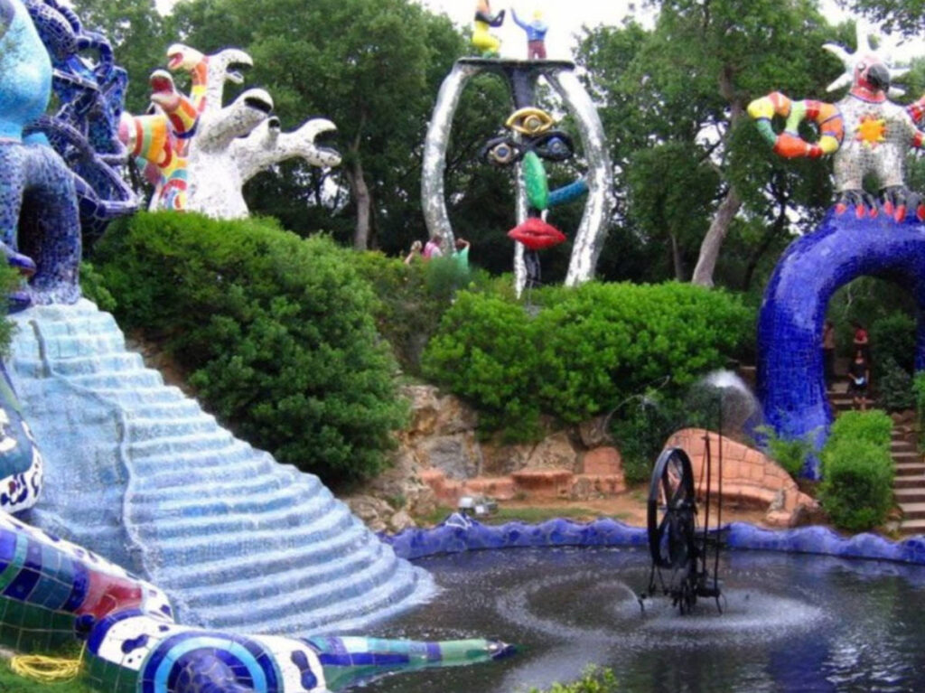 The colorful art installations around the fountain in The Popess