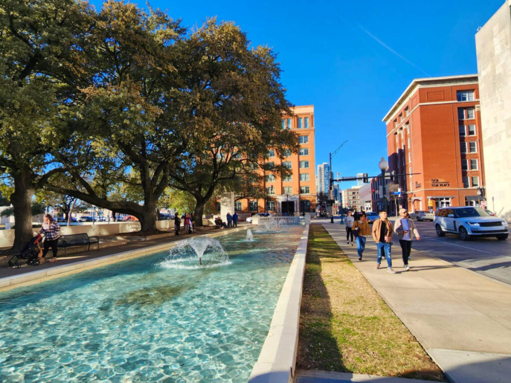 Fountain with people walking in The Sixth Floor Museum at Dealey Plaza