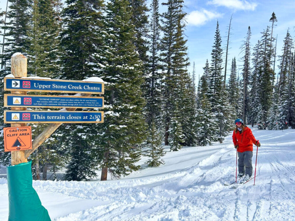 The author Abigail Bliss's husband, posing near the signage of The Upper and Lower Stone Creek Chutes