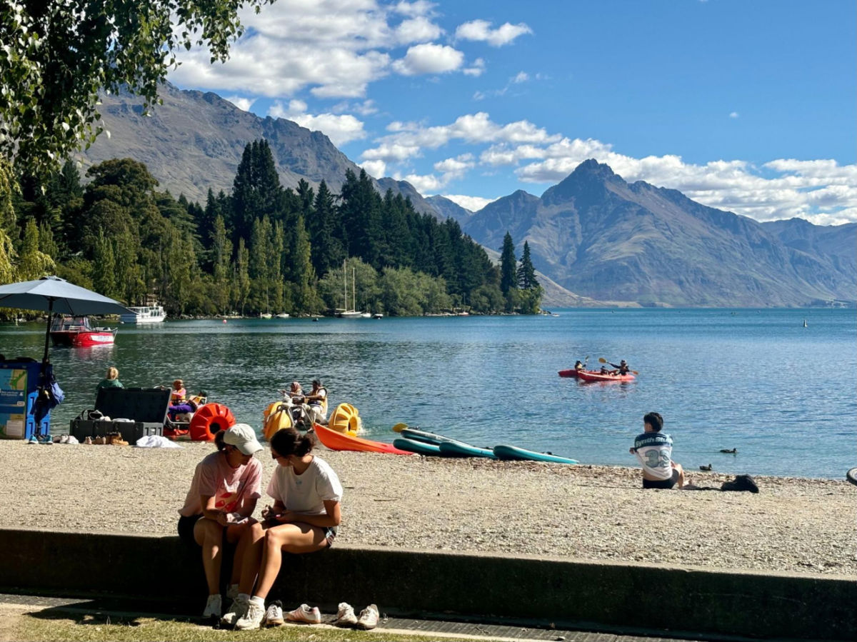 People kayaking and relaxing at a beach in Lake Wakatipu