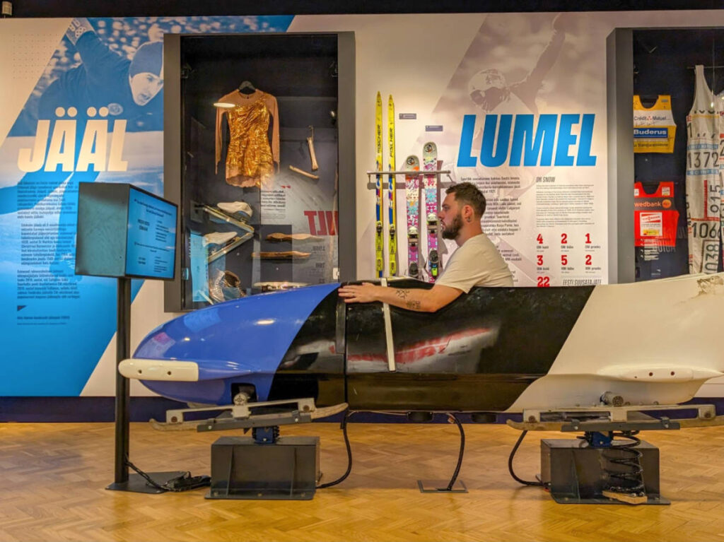 The author Thom Brown, testing out the bobsled in the Estonian Sports Museum