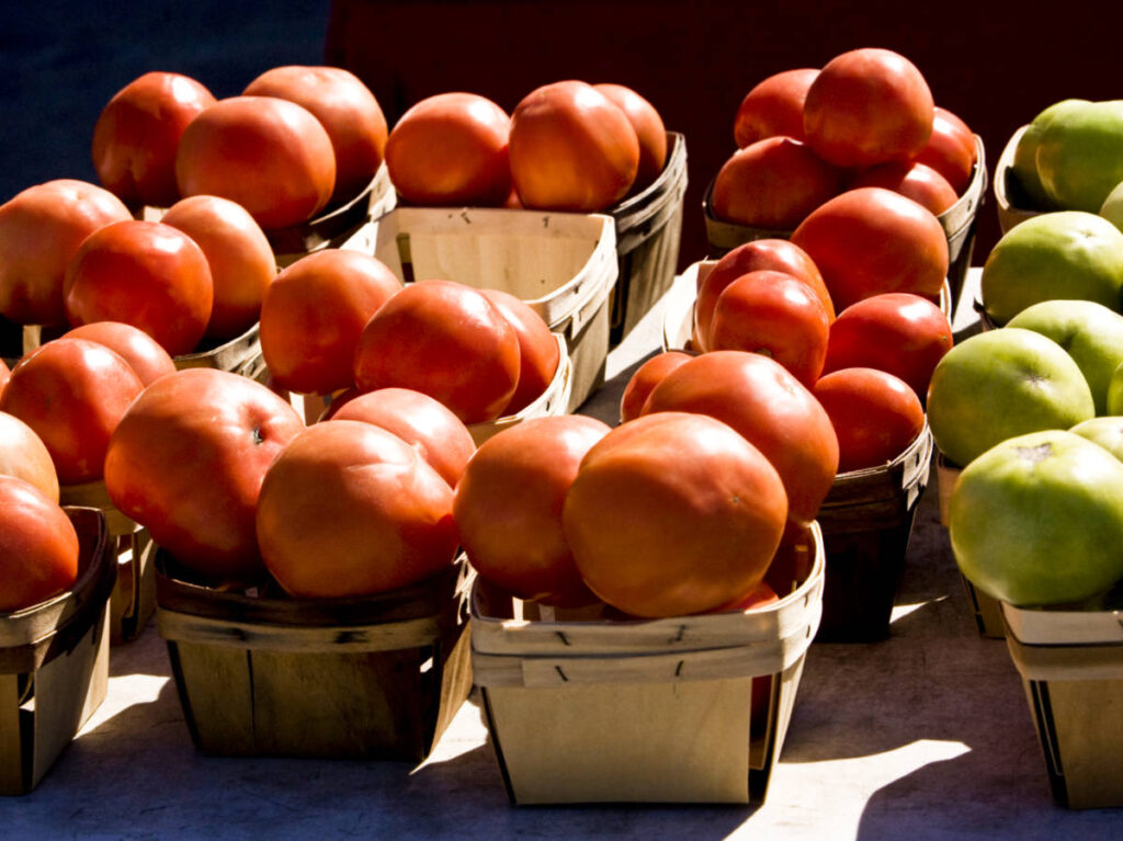 Baskets full of red and green tomatoes