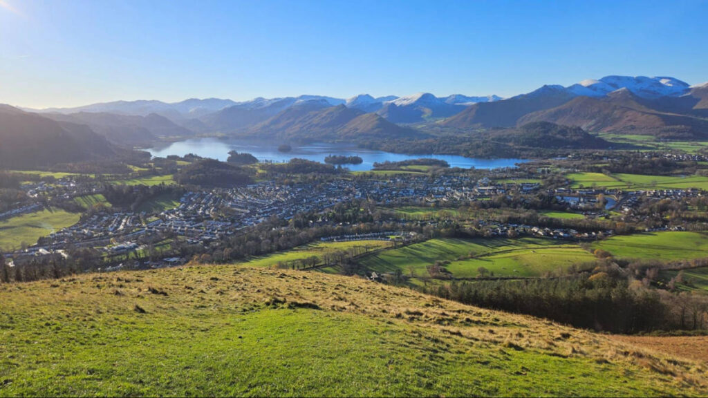 Panoramic view of the lakeside town of Keswick surrounded by greenery