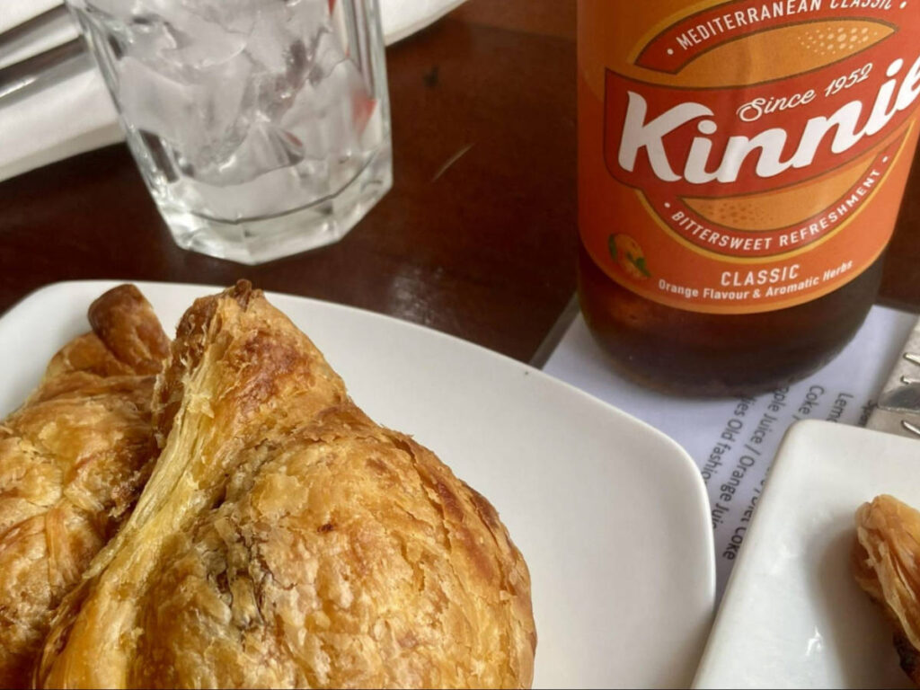 The traditional pastizzi on a plate and a classic Kinnie