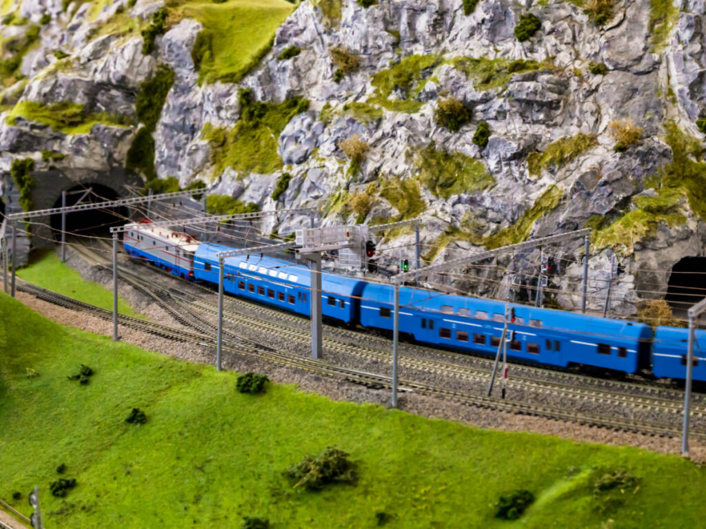 A diorama of a blue train entering the tunnel