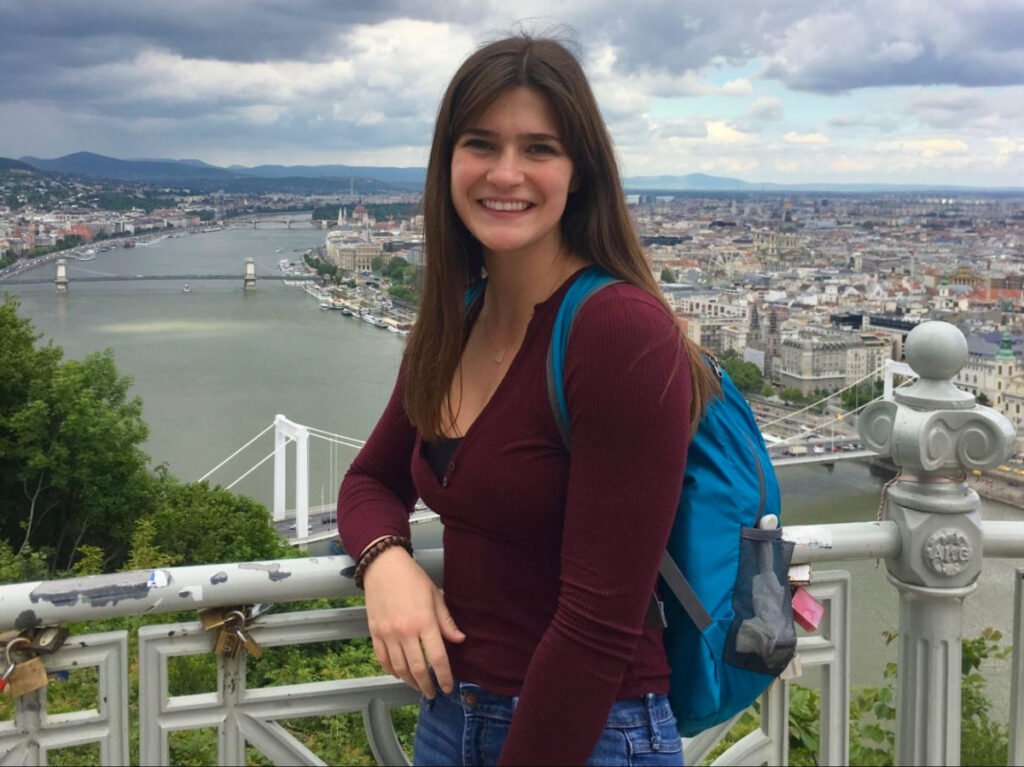 Travel Lemming writer Betty posing with a view of a city below