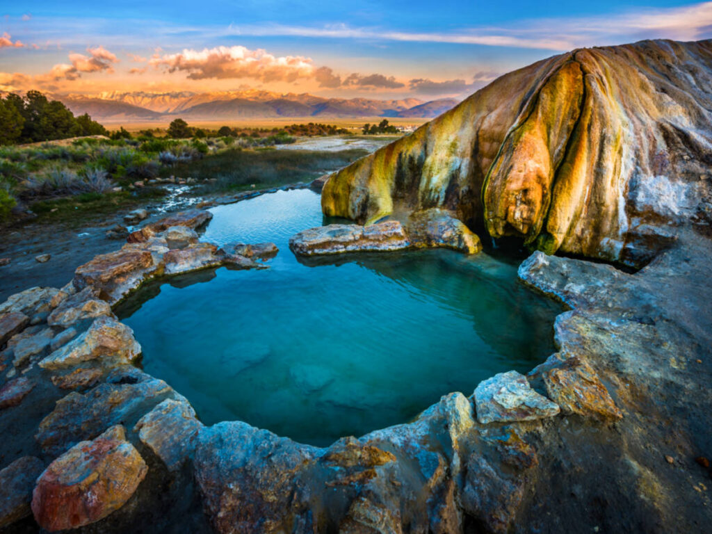 Aerial view of the Travertine Hot Spring with the Sierra Mountains in the background at dusk