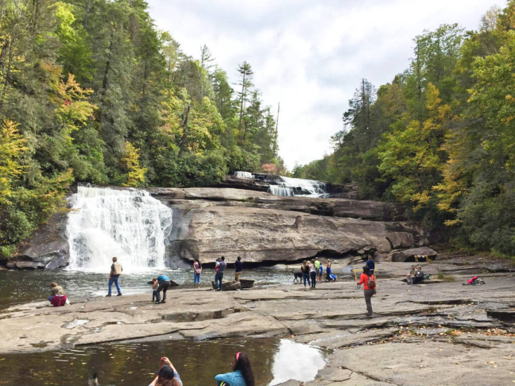 The people enjoying the majestic views of Triple Falls in early autumn