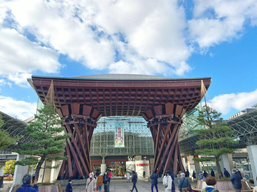 People walking around the Tsuzumimon Gate at the entrance to JR Kanazawa Station