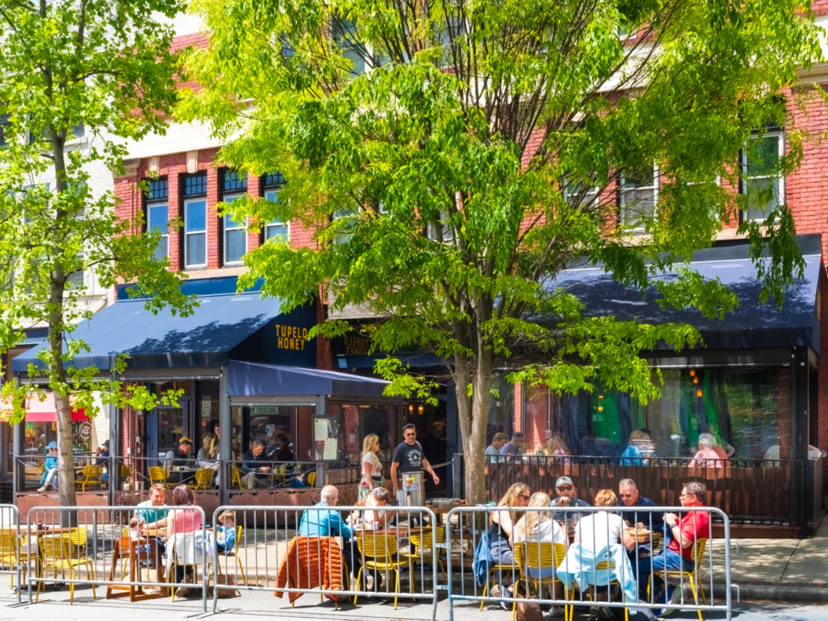 View of people dining outside near the road at Tupelo Honey