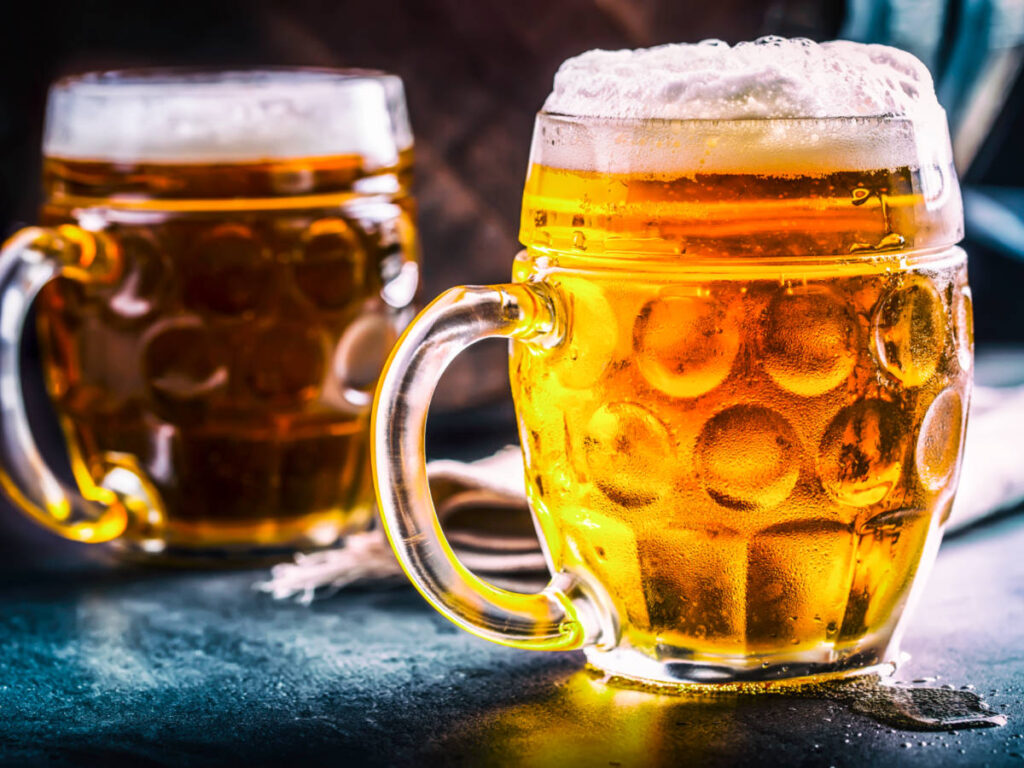 Closeup look of the two glasses of cold beers with foam on top