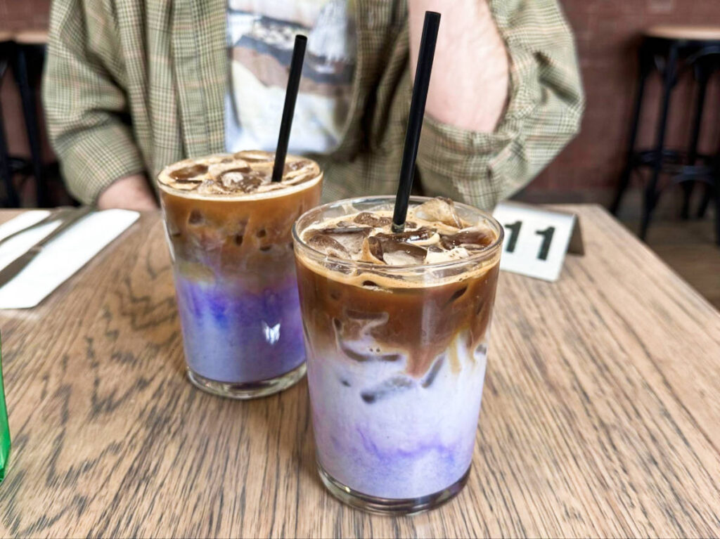 Two glasses of ube lattes served on the table