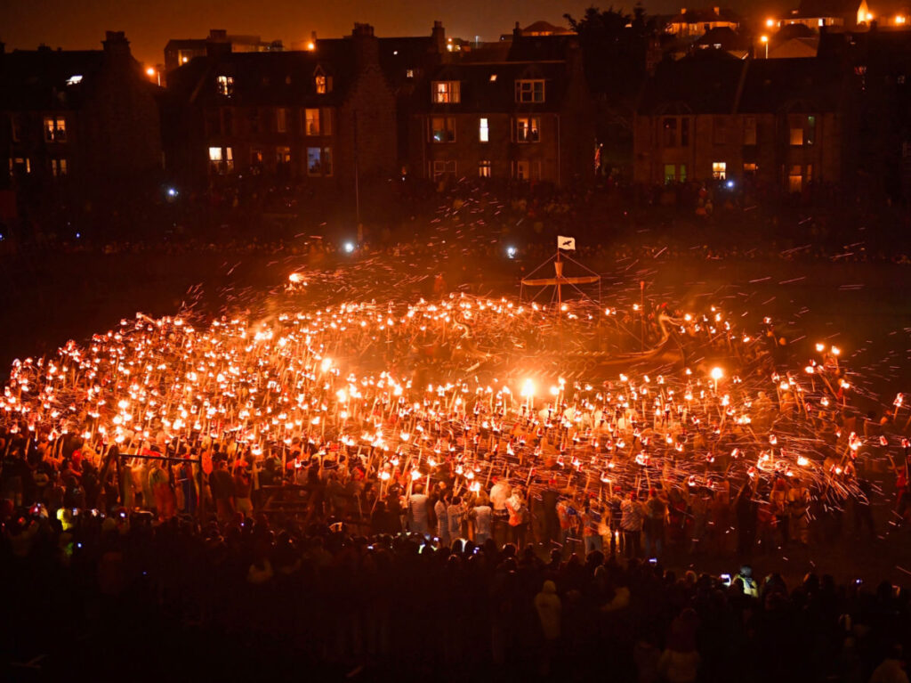 A large crowd of people holding torches at Up Helly Aa Festivals