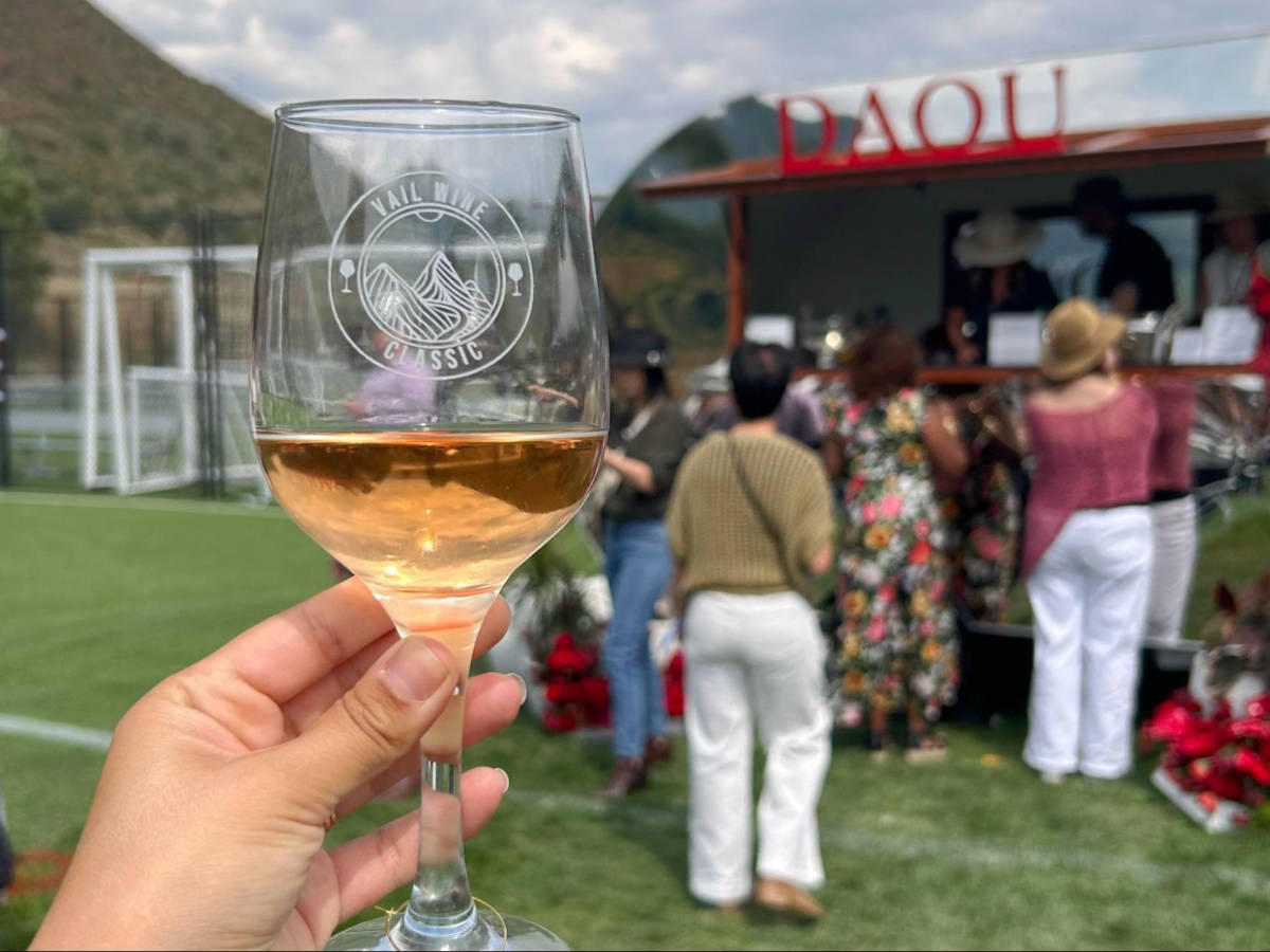A hand holding a glass of Vail Wine Classic