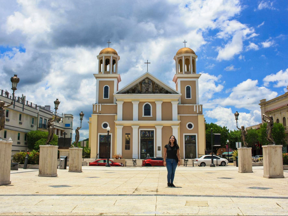 The author Vanessa Ramos, posing in front of a church at Plaza Colon
