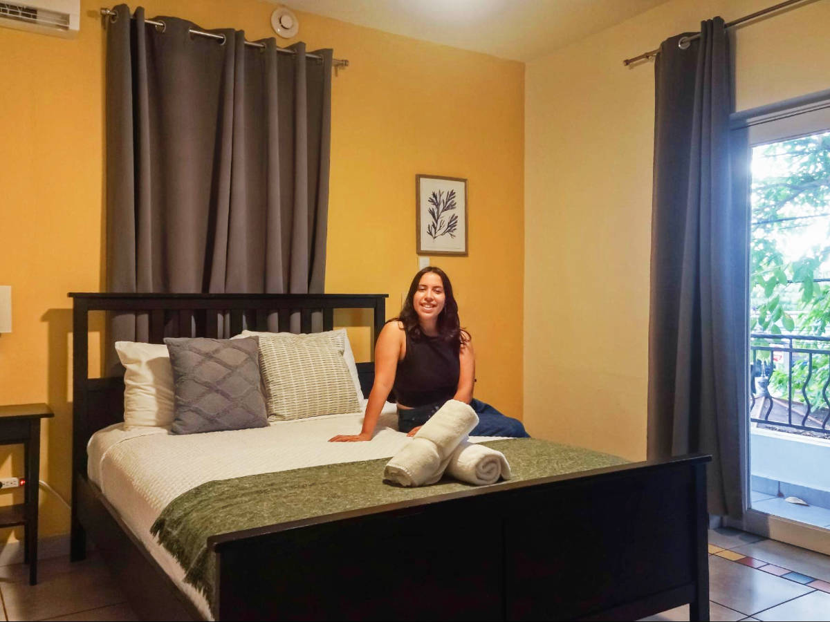 The author, Vanessa Ramos sitting on a bed at Rincon Plaza Hotel