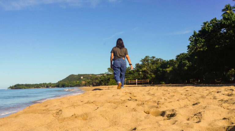 The author Vanessa Ramos walking along the sandy beach