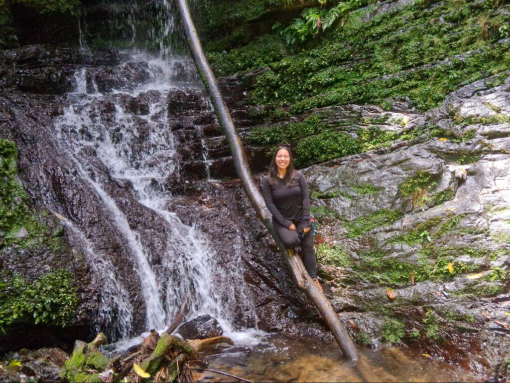 The author Vanessa Ramos, posing for a photo at the bottom of the waterfall