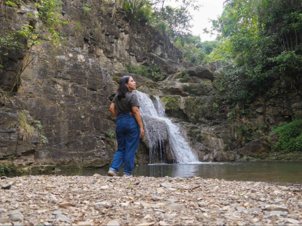 The author Vanessa Ramos, standing in front of the waterfalls at El Último Brinco