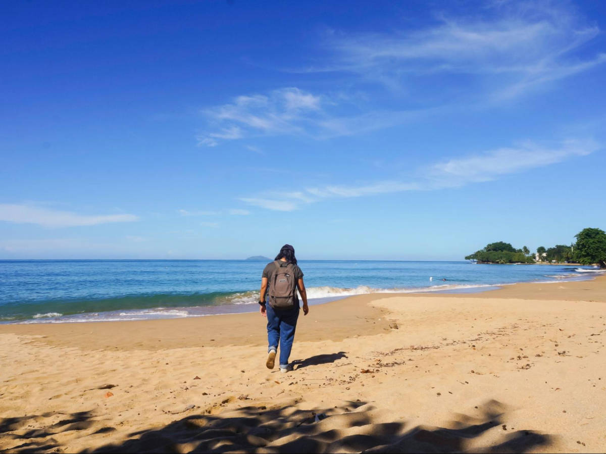 The author Vanessa Ramos walking along the sandy beach at Rincón Public Beach