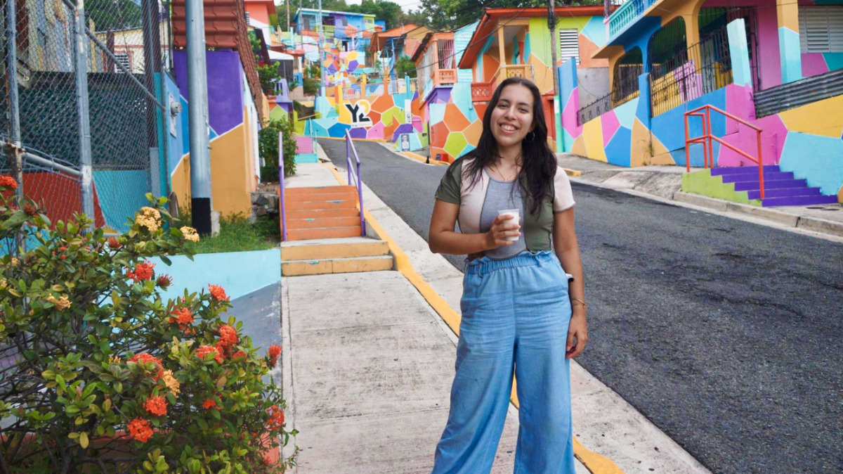Travel Lemming Writer, Vanessa, holding a cup of coffee and posing at Yaucromatic in Yauco