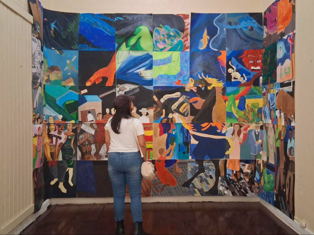 The author Vanessa Ramos, looking at the colorful mural in Aguadilla Art Museum