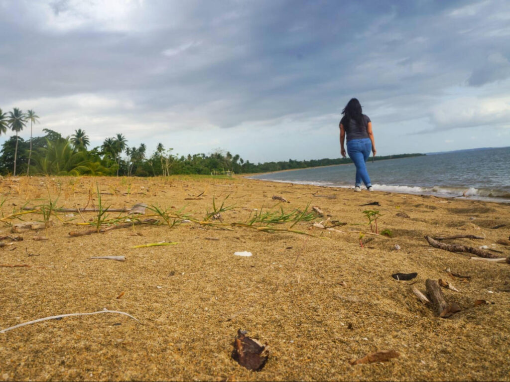The author Vanessa Ramos, walking along the shoreline in Balneario Tres Hermanos