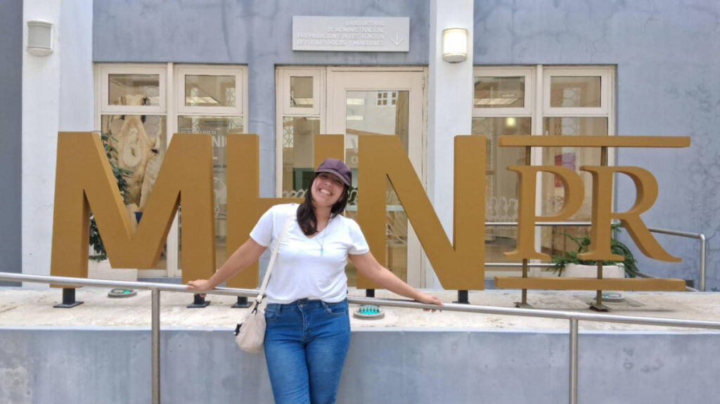 The author Vanessa Ramos, posing for a photo in front of the signage outside Museo de Historia Natural de Puerto Rico