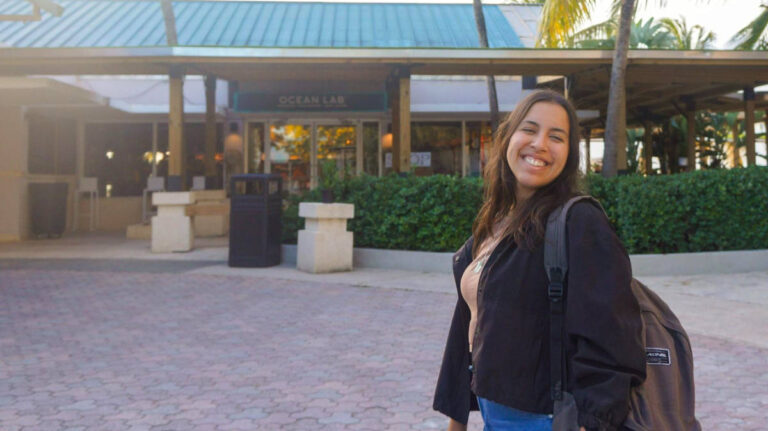 The author Vanesa Ramos, smiling for a photo in front of the entrance of Ocean Lab Brewery