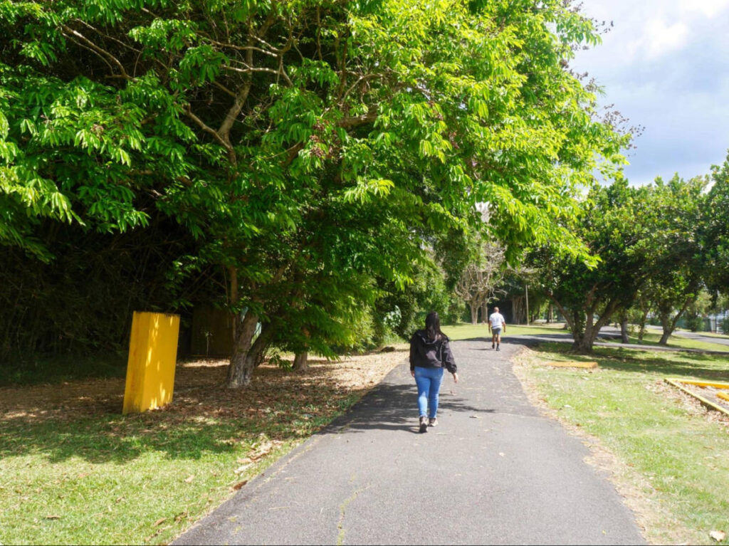 The author Vanessa Ramos, walking along a pathway surrounded by greenery in Parque Julia de Burgos