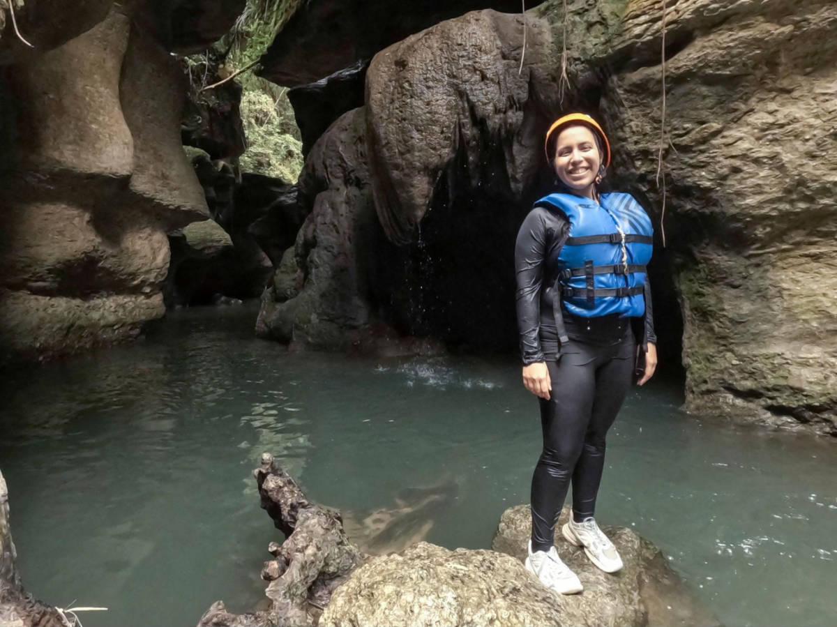 The author Vanessa Ramos, standing on a rock in a cave in Charco Azul