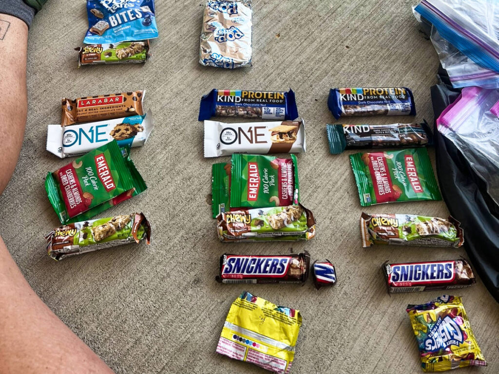 Snacks, nuts, chocolate and protein bars laid out on the floor